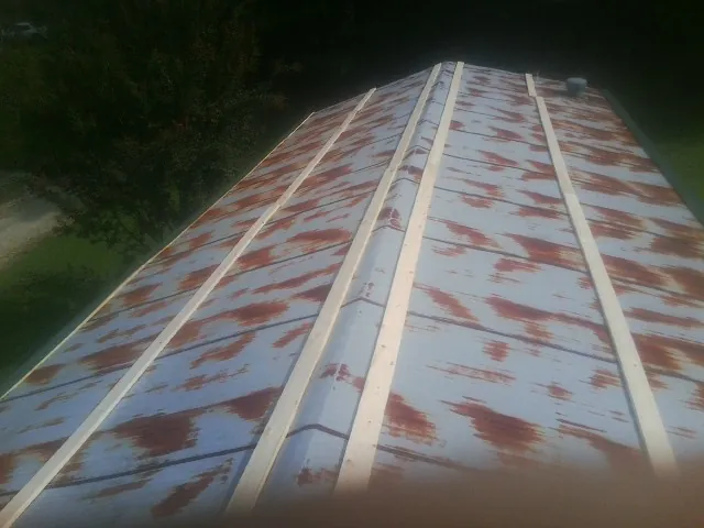 Rusted metal roof panels with new wood purlins before replacement — Storm Damage Roof Repair in Dammeron Valley by Roofing Brothers