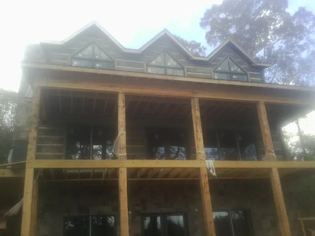 Dormers and porch framing on a large log home under construction — Roof Coating work by our crew in Dammeron Valley
